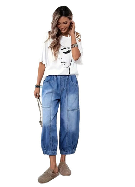 Woman wearing a white t-shirt with a graphic design and blue jeans on a white background