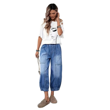 Woman wearing a white t-shirt with a graphic design and blue jeans on a white background