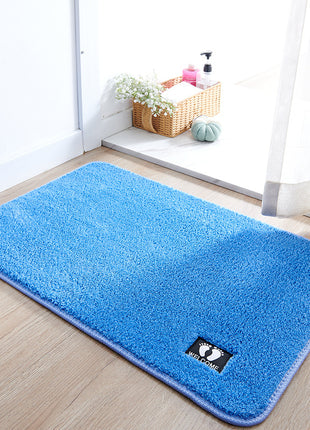 Blue rug on a wooden floor with a brand logo in a room setting.