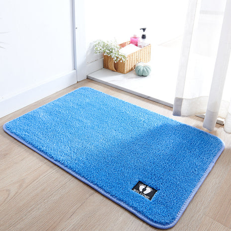 Blue rug on a wooden floor with a brand logo in a room setting.
