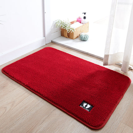 Red doormat with a 'Welcome' label on a wooden floor.