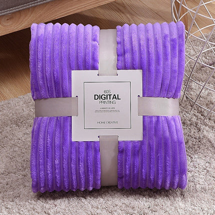 Purple blanket with a brand tag on a carpeted floor