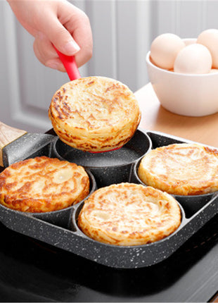 Person using a non-stick muffin pan with freshly baked muffins on a kitchen counter.