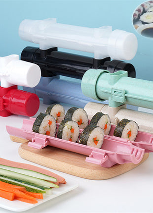 Sushi-making kit with colorful rollers and pre-made sushi on a light blue background