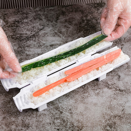 Sushi-making process with a sushi roller and ingredients on a gray surface.