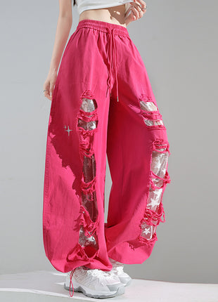 Pink pants with rhinestone embellishments on a gray background