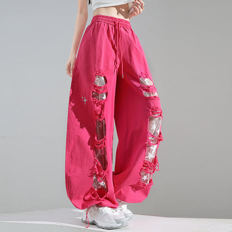 Pink pants with rhinestone embellishments on a gray background