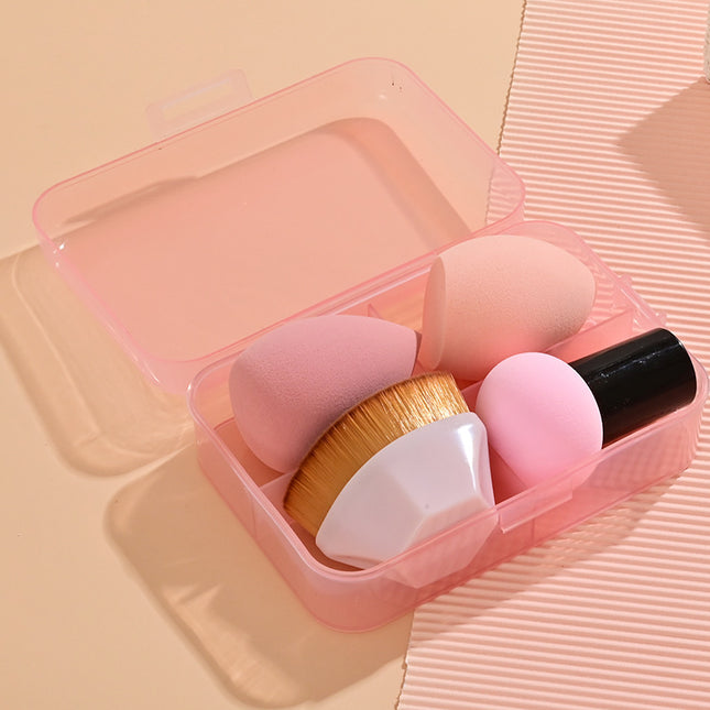 Set of makeup brushes in a pink case on a matching pink background