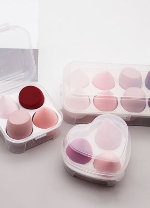 Set of makeup sponges in clear containers on a light background