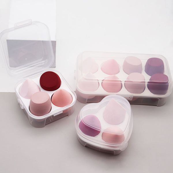 Set of makeup sponges in clear containers on a light background