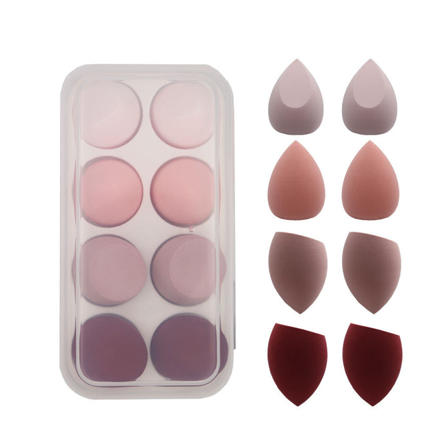 Set of makeup sponges in various shapes and colors on a white background