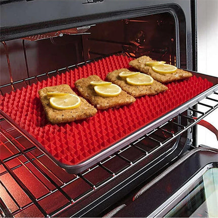 Red silicone baking mat with food items on an open oven