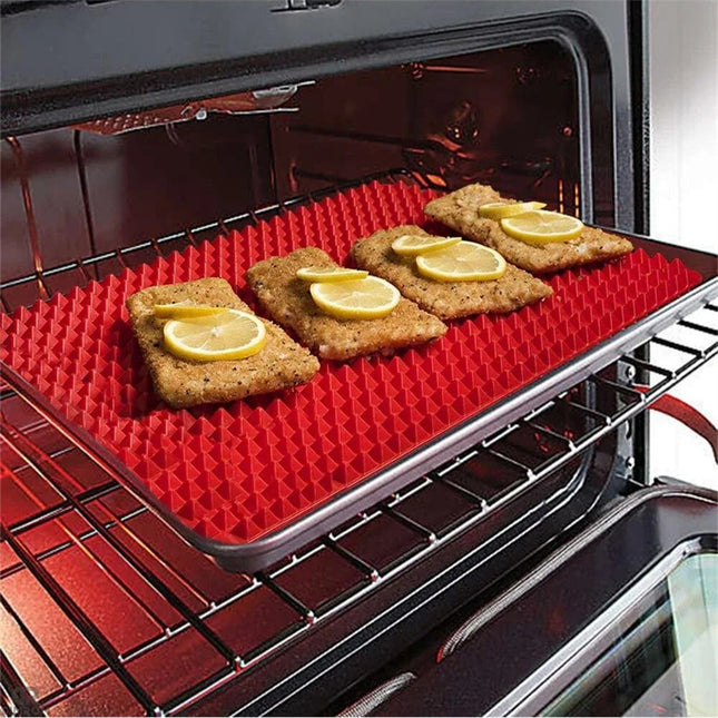 Red silicone baking mat with food items on an open oven