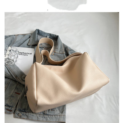 Beige handbag on a denim jacket with a white background