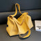 Yellow handbag on a dark surface with a blurred background