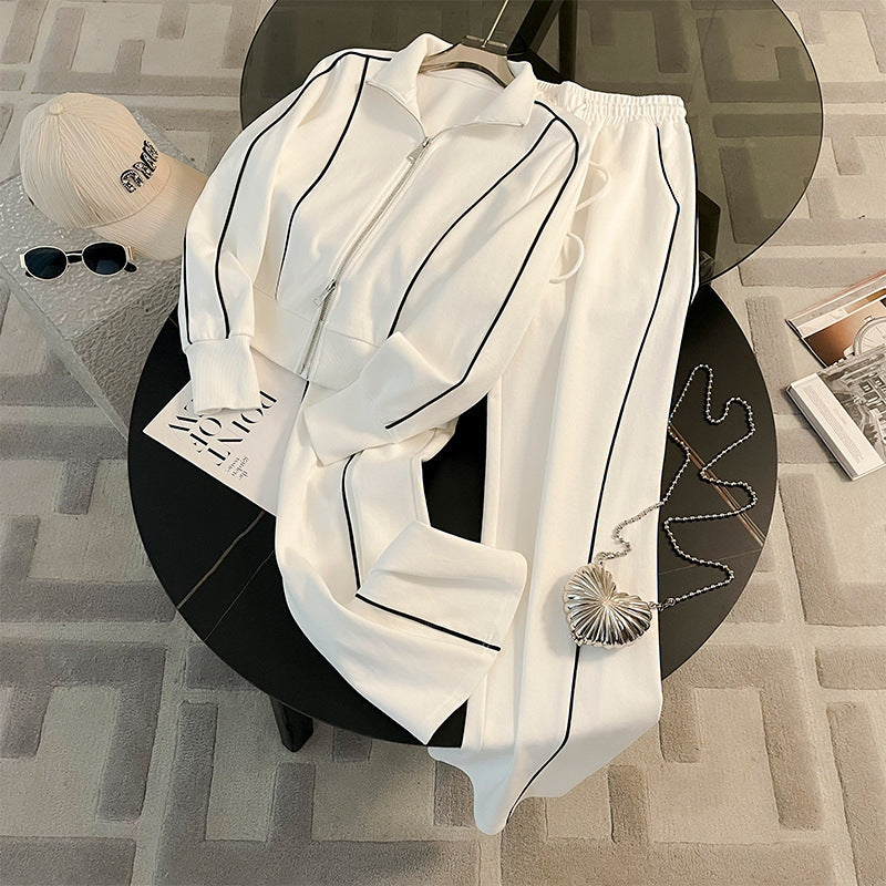 White outfit with black stripes on a black stool against a patterned floor.