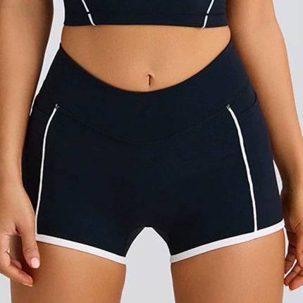 Black athletic shorts with white accents on a neutral background