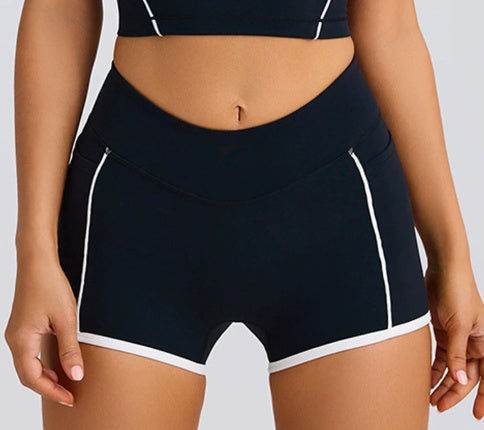 Black athletic shorts with white accents on a neutral background