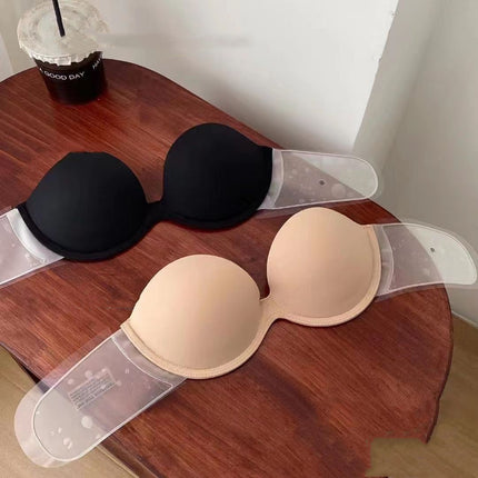 Black and beige bras on a wooden table with a cup of coffee in the background.