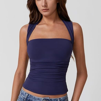 Woman wearing a navy blue tank top against a plain background