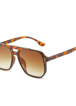 Sunglasses with tortoiseshell frame and brown gradient lenses on a white background