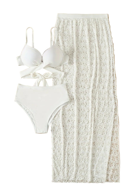 White bikini set and lace skirt on a wooden surface with sandals.