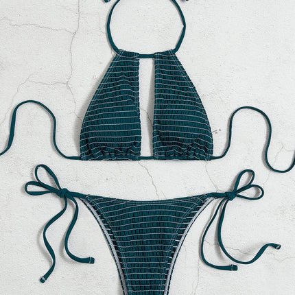 Teal bikini set with criss-cross straps on a light gray background
