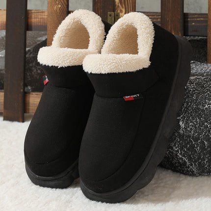 Black slippers with white fuzzy lining on a textured surface