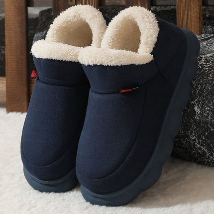 Pair of navy blue slip-on boots with white fuzzy lining on a light background
