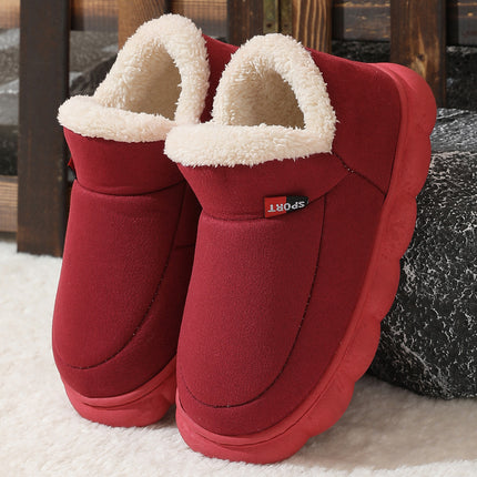 Red slippers with white fur lining on a textured surface