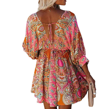 Woman wearing a colorful dress against a textured wall.