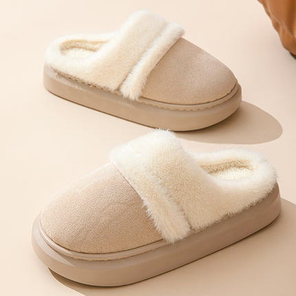 Pair of beige slippers with white fur trim on a beige background