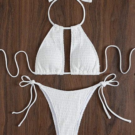 White bikini set with bow details on a wooden surface