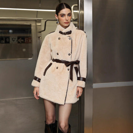 Woman wearing a cream fur coat with brown accents in an indoor setting