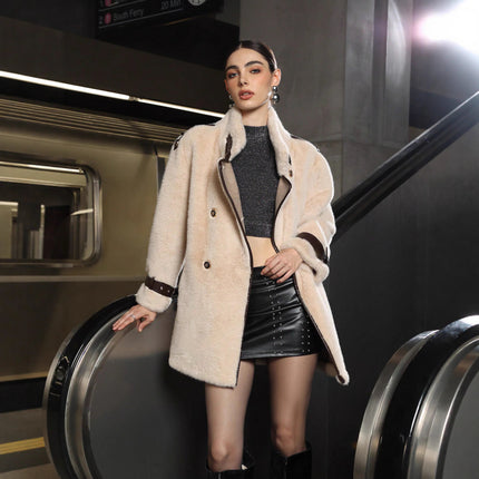 Woman in a stylish outfit standing next to an escalator in an urban setting