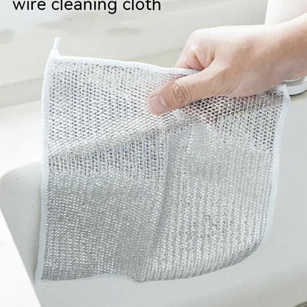 Wire cleaning cloth held by a hand over a sink