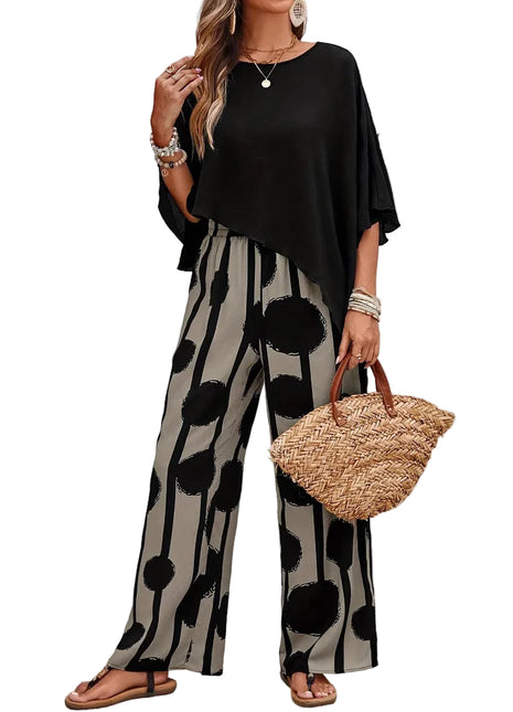 Woman wearing a black top and polka dot pants holding a straw bag outdoors.