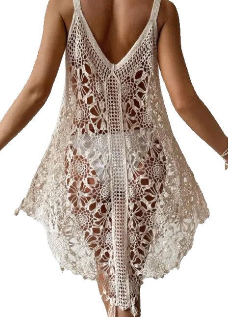 Woman wearing a beige crochet dress against a plain background