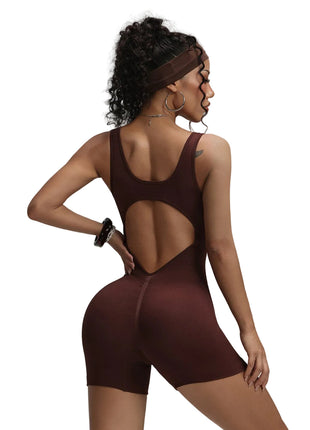 Woman wearing a brown bodysuit with cut-out design on a plain background