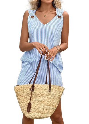 Woman holding a straw bag outdoors with decorative pots and plants in the background