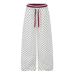 Women's ruffle-trimmed polka dot straight-leg pants featuring a mid-rise waist and cotton fabric.