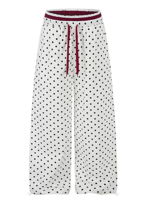 Women's ruffle-trimmed polka dot straight-leg pants featuring a mid-rise waist and cotton fabric.