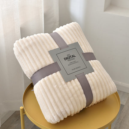 Folded beige blanket with a gray strap and label on a yellow stool.