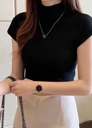 Person wearing a black sleeveless top and a watch, with a neutral background