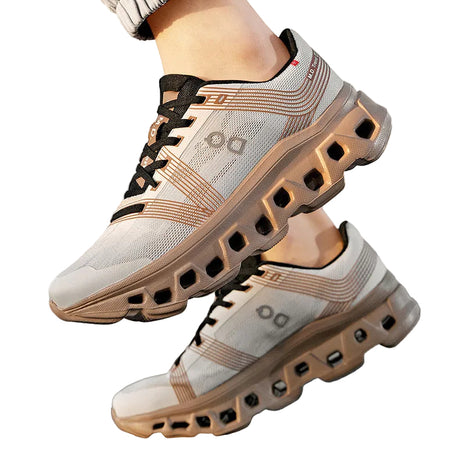 blndl White and beige athletic shoes with black accents on a blurred outdoor background