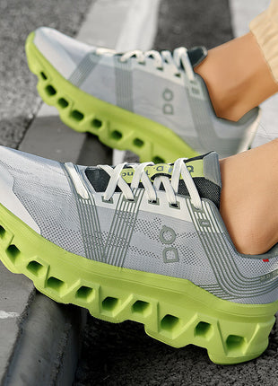Gray and green athletic shoes on a person's feet with a textured gray background