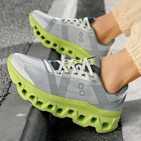 Gray and green athletic shoes on a person's feet with a textured gray background