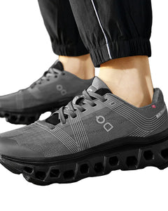 Gray athletic shoes with unique sole design worn outdoors on a paved surface