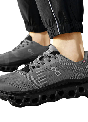 Gray athletic shoes with unique sole design worn outdoors on a paved surface