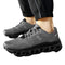 Gray athletic shoes with unique sole design worn outdoors on a paved surface